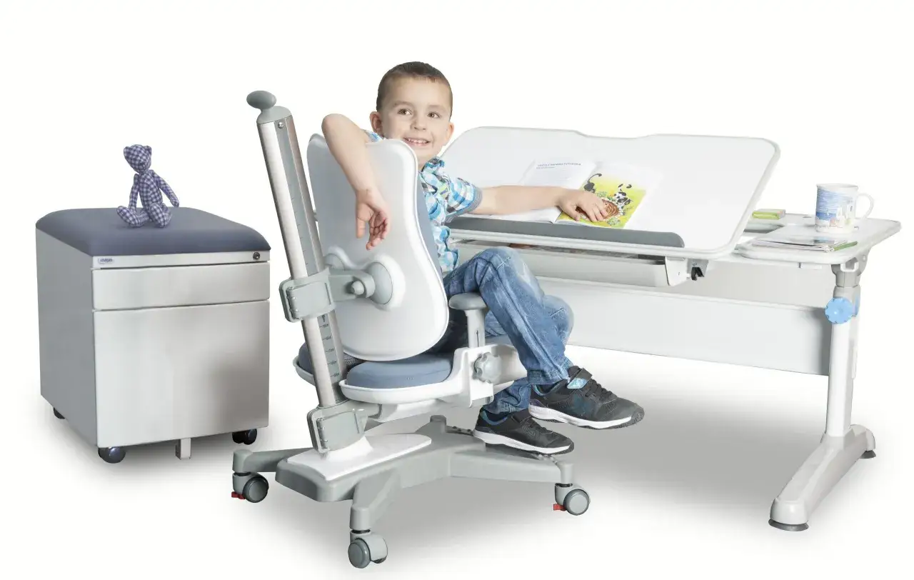 dziecko przy biurku na ergonomicznym krześle z prawidłową postawą